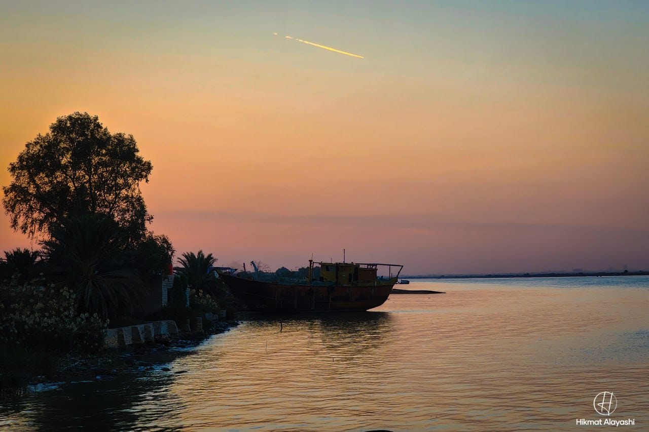 boat resting near the river bank at sunset in Basra