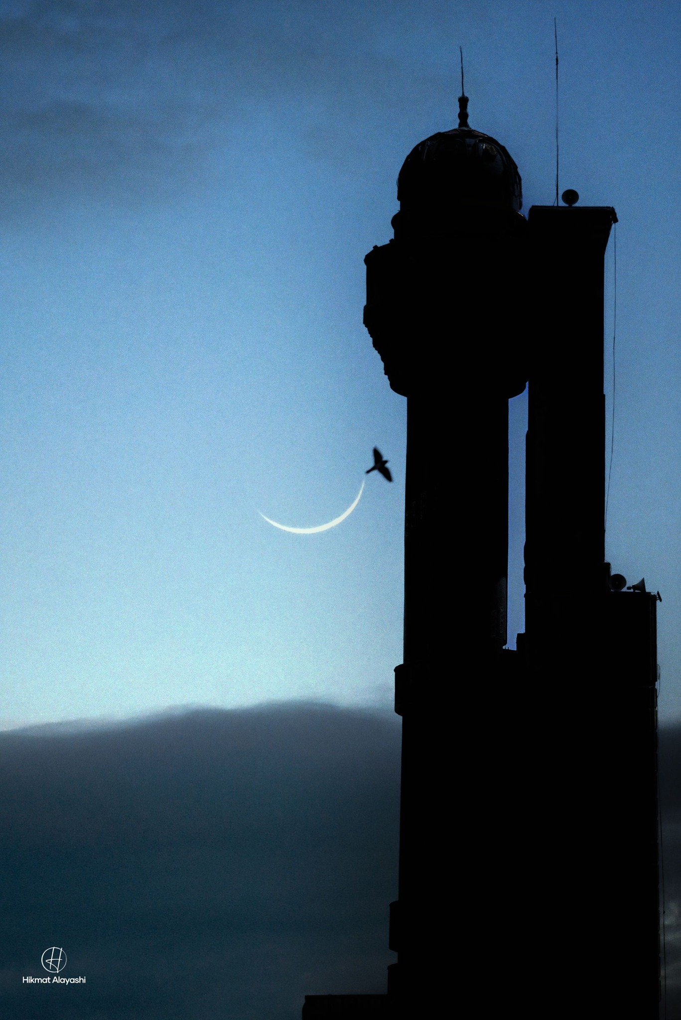 banana moon beside a mosque minaret in the Iraqi sky