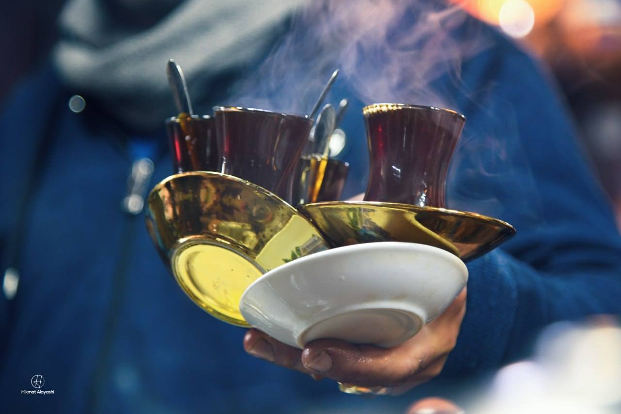 traditional Iraqi tea cups being carried on trays