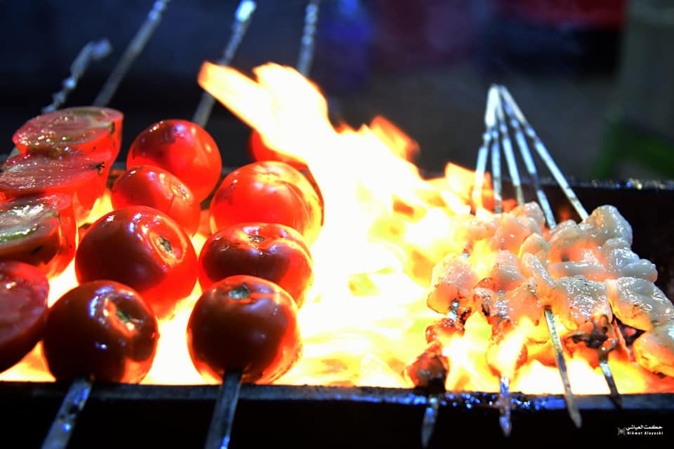 grilled meat and vegetables on skewers over fire